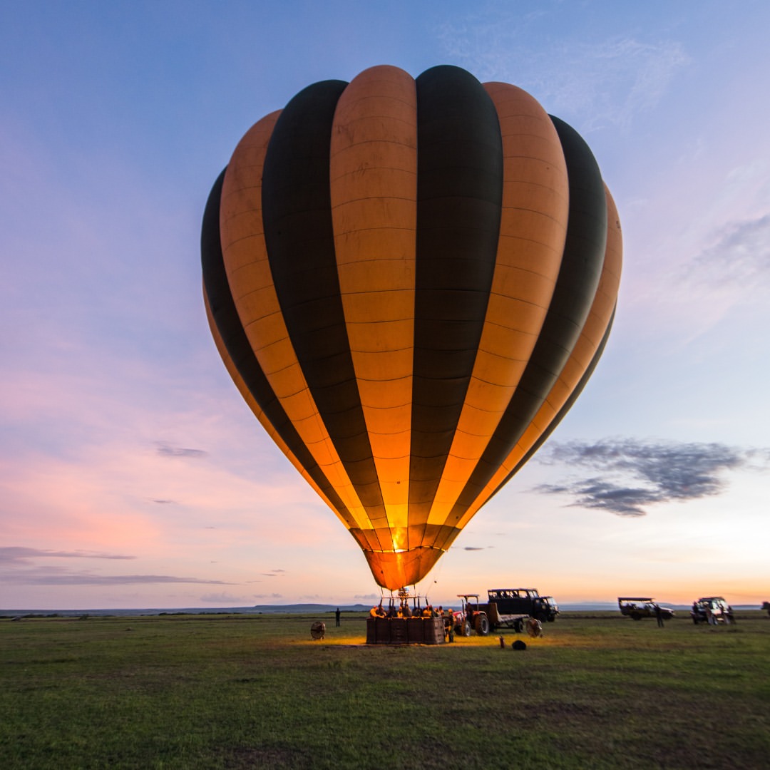 Hot-air balloon lifting off at dawn over the Serengeti plains